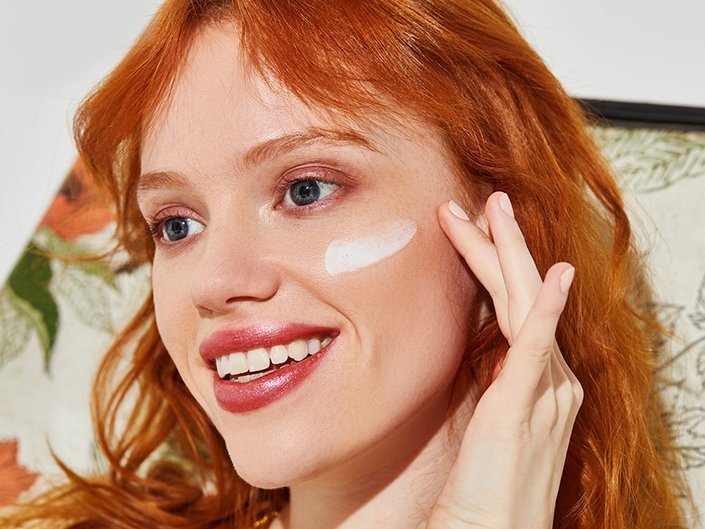 picture of a person applying moisturizer to cheekbone